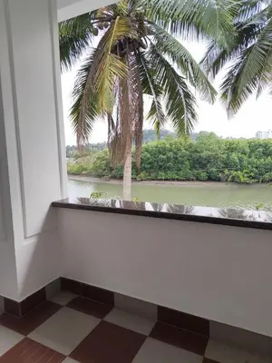 a window with a palm tree and a river at Retreat Rivera where Serenity Meets the River in Green Island
