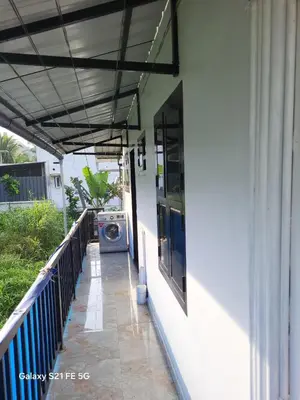 a washer and dryer on a porch of a house at Home stay in Manjeri