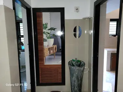 a hallway with a mirror and a vase in a room at Home stay in Manjeri