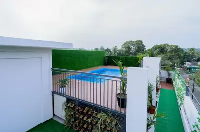 a balcony with a swimming pool and plants at Munderi Green Mounts - Family Rooms with Swimming Pool in Kalpetta