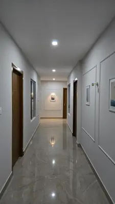 a hallway of a building with white walls and a tile floor at Munderi Green Mounts - Family Rooms with Swimming Pool in Kalpetta
