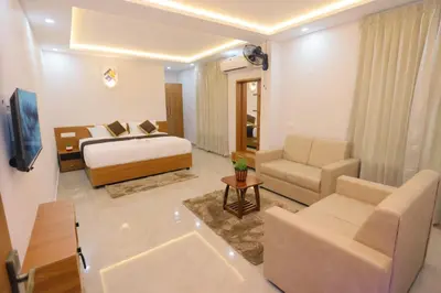 a hotel room with a bed and a living room at Munderi Green Mounts - Family Rooms with Swimming Pool in Kalpetta