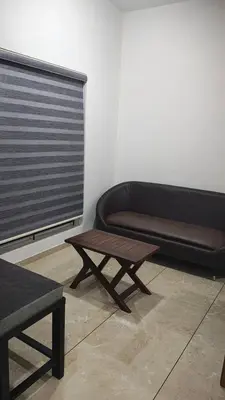 a couch and a coffee table in a room at Satori Stays - KMA Apartments in Kozhikode