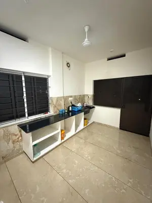 a kitchen with black and white cabinets and a counter at Satori Stays - KMA Apartments in Kozhikode