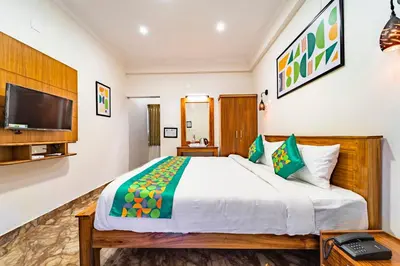 a bedroom with a large bed and a flat screen tv at Treebo Lumino Crown, 850 Meters From Ooty Lake in Ooty