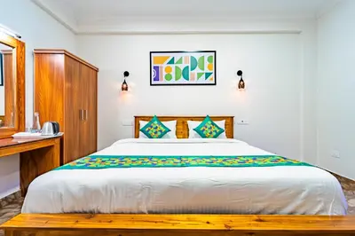 a bedroom with a large bed and a desk at Treebo Lumino Crown, 850 Meters From Ooty Lake in Ooty