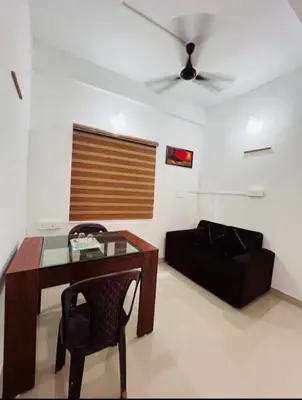 a living room with a table and a couch at Calicut residency in Kozhikode