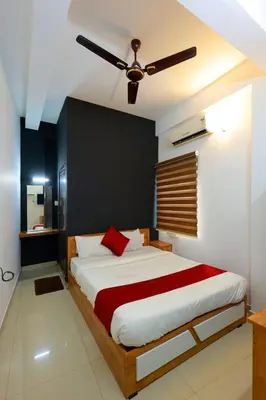 a bedroom with a large bed with a ceiling fan at Calicut residency in Kozhikode