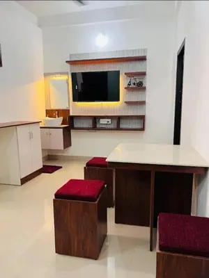 a kitchen with a table and stools in a room at Calicut residency in Kozhikode