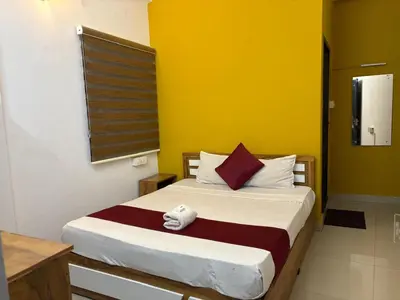 a bedroom with a bed with a yellow wall at Calicut residency in Kozhikode