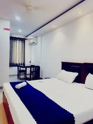 a bedroom with a large bed and a table at Metro Residency in Perintalmanna