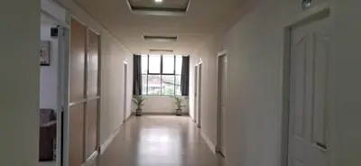an empty hallway with two potted plants and a window at Metro Residency in Perintalmanna