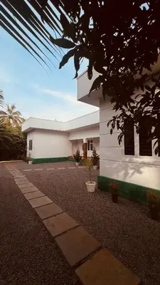 a white house with a pathway in front of it at Green Villa Chirackal Gardens in Trichūr