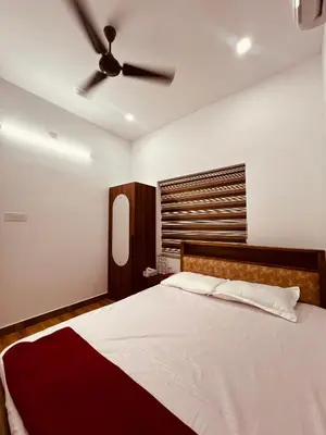 a bedroom with a bed with a ceiling fan at Green Villa Chirackal Gardens in Trichūr