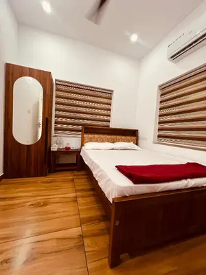 a bedroom with a bed and a mirror at Green Villa Chirackal Gardens in Trichūr