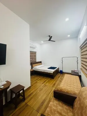 a living room with a bed and a couch at Green Villa Chirackal Gardens in Trichūr