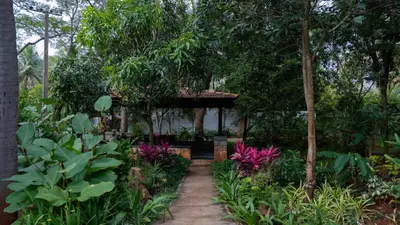 a garden with a pergola in the middle at Trisara Boutique Stay in Mysore