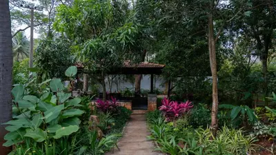 a garden with a pergola in the middle at Trisara Boutique Stay in Mysore