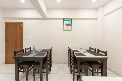 a dining room with two tables and chairs at Treebo Adithi Comforts Inn And Suites in Mysore