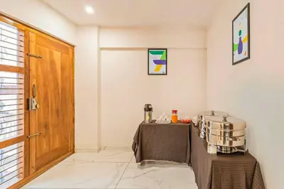 a room with a table and a wooden door at Treebo Adithi Comforts Inn And Suites in Mysore