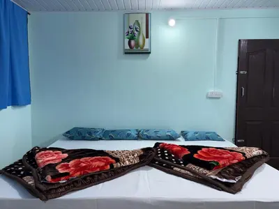 a bed with two blankets on top of it at BN HOMESTAY be nature in Devikolam