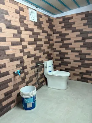 a bathroom with a toilet in a brick wall at BN HOMESTAY be nature in Devikolam