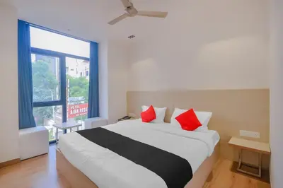 a bedroom with a large bed with red pillows at capital o hotel paradise international in Coimbatore