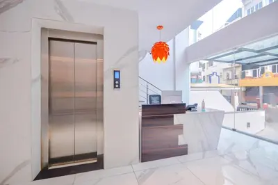 a lobby with a glass door in a building at capital o hotel paradise international in Coimbatore