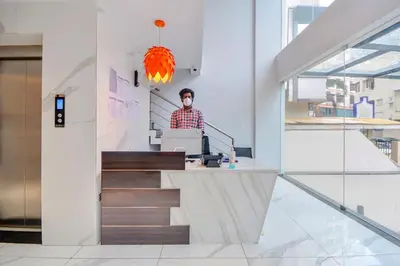 a man sitting at a desk in a building at capital o hotel paradise international in Coimbatore