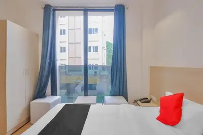 a bedroom with a bed and a large window at capital o hotel paradise international in Coimbatore