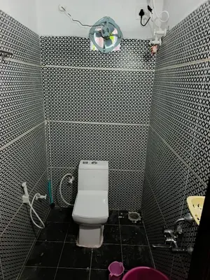a bathroom with a white toilet and a sink at JK Cottages in Suntikoppa