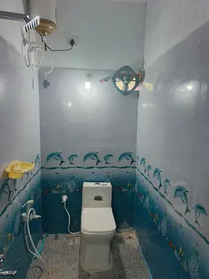 a bathroom with a toilet with dolphins painted on the walls at JK Cottages in Suntikoppa