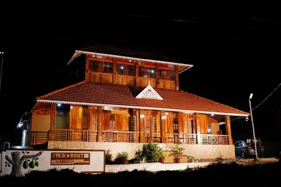 a large wooden building with a sign in front of it at Jackroot Heritage wood villa Athirappilly in Kallana