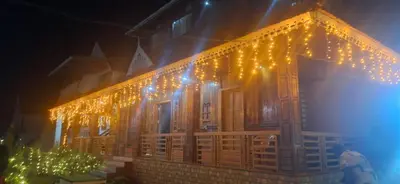 a string of lights on the side of a building at Jackroot Heritage wood villa Athirappilly in Kallana