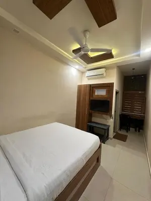 a bedroom with a bed and a ceiling fan at MK Residency Calicut near Baby Memorial Hospital in Kozhikode