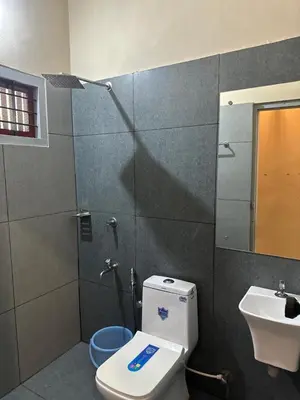 a bathroom with a shower and a toilet and a sink at MK Residency Calicut near Baby Memorial Hospital in Kozhikode