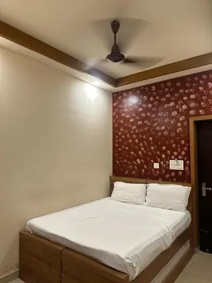 a bed in a room with a wall with at MK Residency Calicut near Baby Memorial Hospital in Kozhikode