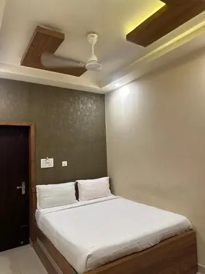 a bed in a room with a ceiling at MK Residency Calicut near Baby Memorial Hospital in Kozhikode
