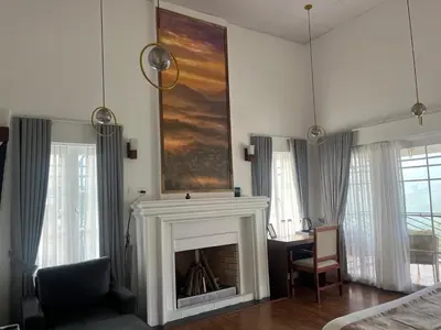 a living room with a fireplace and a chair and a table at Memories at The Blue Mountains in Kotagiri