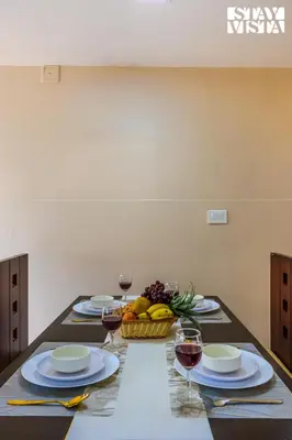 a table with glasses of wine and a basket of fruit at Mistydawn Villas By Sunset Valley by VEO - Part of StayVista in Ooty