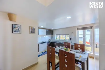 a kitchen and dining room with a table and chairs at Mistydawn Villas By Sunset Valley by VEO - Part of StayVista in Ooty