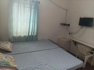 a small bedroom with two beds and a window at chenniyappa lodge in Chennimalai
