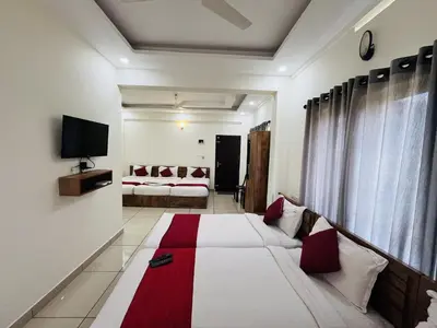 a hotel room with a bed and a tv at Homey - vythiri bus station in Vythiri