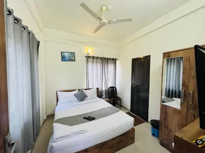 a bedroom with a bed and a television in it at Homey - vythiri bus station in Vythiri