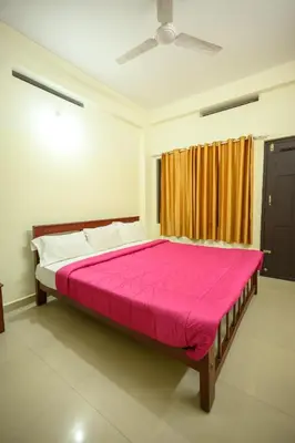 a bedroom with a large bed with a pink blanket at Skybz Resort - Mankulam in Viripara