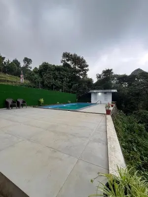 a patio with a swimming pool in a backyard at Skybz Resort - Mankulam in Viripara