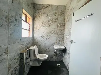 a bathroom with a toilet and a sink at Green Heaven Mysore Homestay in Mysore