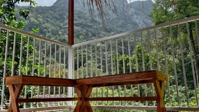 a wooden bench sitting on a balcony with a view at Zeno Village Resort 900 Kandi Wayanad in Wayanad