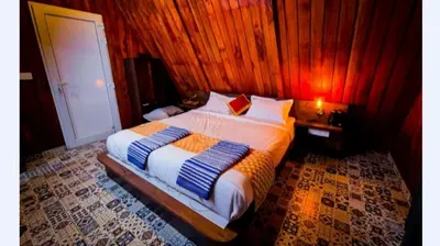 a bedroom with a bed with a wooden wall at Zeno Village Resort 900 Kandi Wayanad in Wayanad
