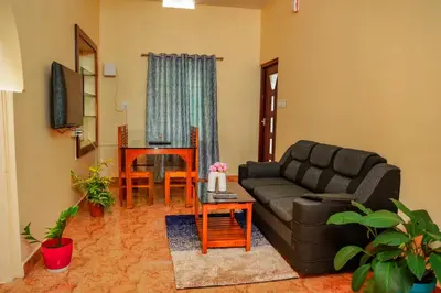 a living room with a couch and a table at Orange Villa -3 AC Rooms Near Airport in Ernakulam